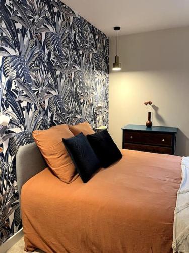 une chambre avec un lit avec deux oreillers dessus dans l'établissement L'orchidée sauvage, au coeur du centre historique, à Lons-le-Saunier