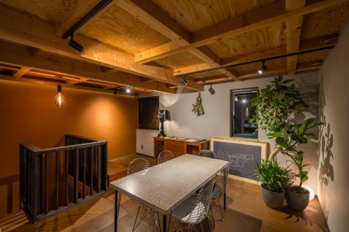 a dining room with a table and a kitchen at HOTEL Sauna&Living in Iwanuma