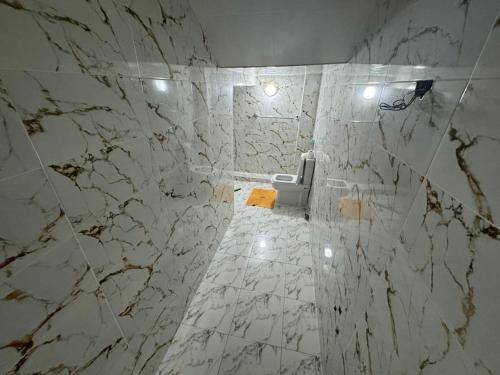 a white marble bathroom with a toilet in it at Dahomey plage appartement Dahomey city in Bouznika