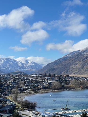 a town next to a body of water with mountains at Stunning Lakeview Holiday House Queenstown in Frankton Wharf