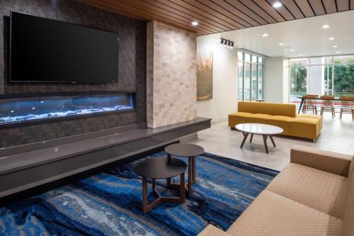 a living room with a fireplace and a tv at Fairfield by Marriott Inn & Suites Anaheim Los Alamitos in Los Alamitos