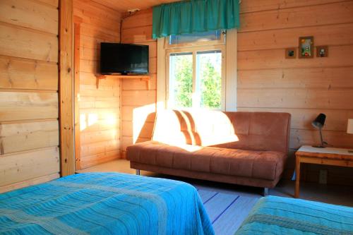 a room with a couch and a television in a cabin at Koskikievari in Lappajärvi