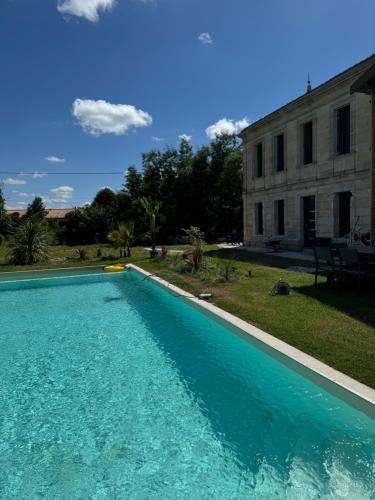 une grande piscine bleue devant un immeuble dans l'établissement Grande Villa de vacances région de bordeaux, à Ambarès-et-Lagrave
