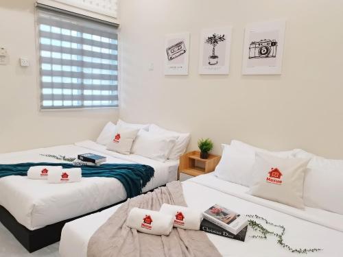 two beds in a room with white walls at 20Pax Town Centre Corner Lot, Near SKT Ballroom in Muar