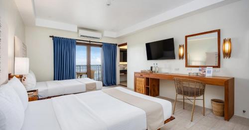 a hotel room with two beds and a mirror at Bluewater Maribago Beach Resort in Mactan