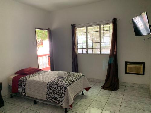 a bedroom with a bed and a window at Hotel La Villa in Retalhuleu