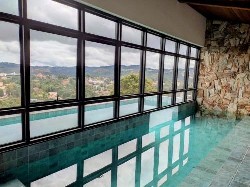 Apartamento com jacuzzi privativa no Wanderlust Hotel في كامبوس دو جورداو: مسبح مطل على الجبال