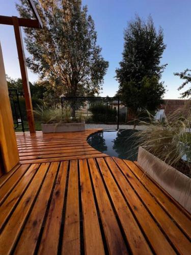 a wooden deck with a view of a pond at Refugio Natural, tu lugar en las sierras in Sierra de los Padres