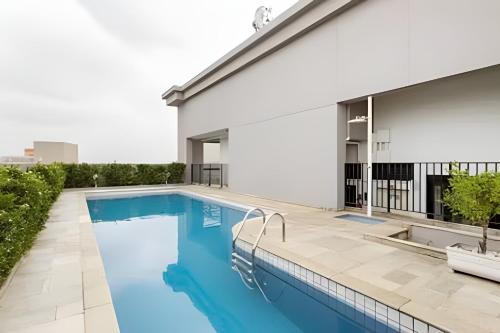 a swimming pool on the roof of a building at Hospedez - Flat Osasco Trade Center in Osasco
