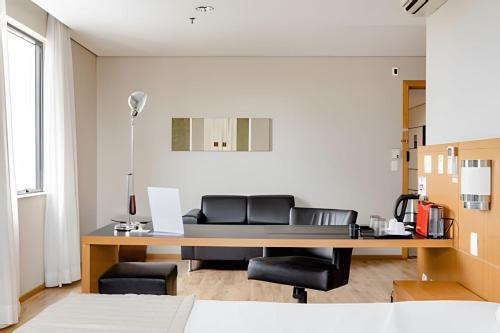 an office with a desk with leather chairs at Hospedez - Flat Osasco Trade Center in Osasco