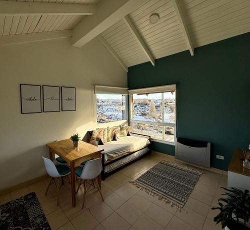 une chambre avec un lit, une table et des chaises dans l'établissement TAAR AIKE II (Lugar de Hielo), à El Calafate