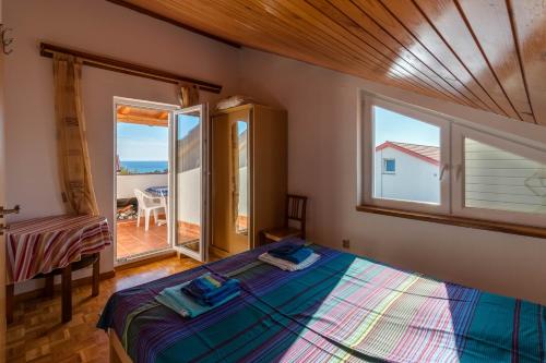 1 dormitorio con cama y ventana grande en Apartment Surfer's lodge, nature driven with Sauna en Krk