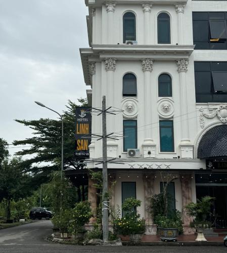 a white building with a sign in front of it at Linh San Hotel in Thinh Làng