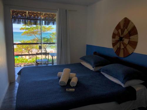 a bedroom with a blue bed with a view of the ocean at Pousada Pipe House in Itacaré