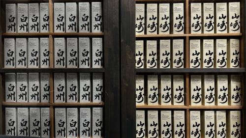 a wall of books with chinese writing on them at 一宿一景一生縁-千葉県市原市小谷田店 in Ichihara