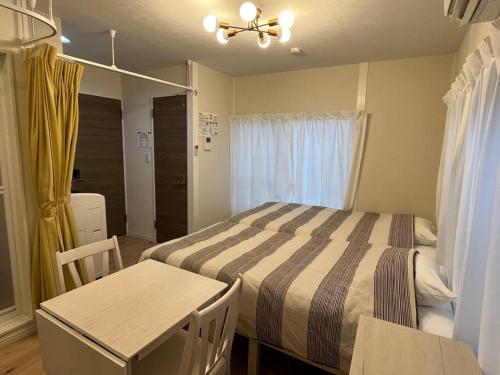 a bedroom with a bed and a table and chairs at Cozy INN 西品川201 in Tokyo