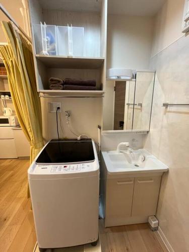 a small white kitchen with a sink and a sink at Cozy INN 西品川201 in Tokyo