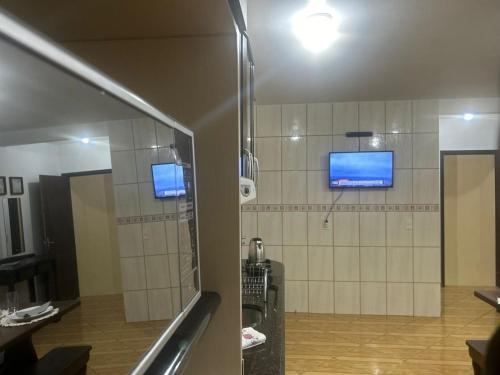 a bathroom with a shower with two monitors on the wall at SOBRADO Com 3 QUARTOS NO CORAÇÃO DO COSTA E SILVA in Joinville