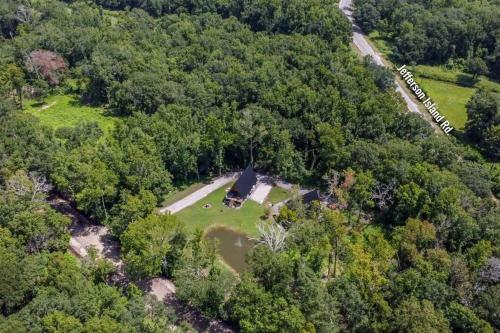 an aerial view of a house in the middle of a forest at Modern A-Frame Cabin by Rip Van Winkle with Hot Tub in New Iberia