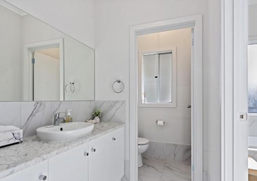 Un baño blanco con lavabo e inodoro. en Nest 6 Battunga Ave Port Elliot - No Linen Included, en Port Elliot