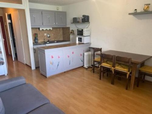 un salon avec une cuisine et une table et des chaises dans l'établissement Studio cosy à Pra-Loup 1600 - 4 pers, balcon, casier à ski - FR-1-165A-191, à Uvernet