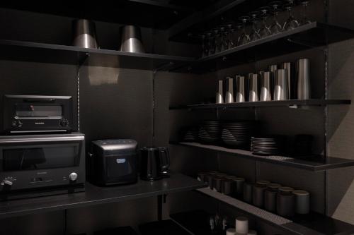 a kitchen with black shelves and a microwave at 清風荘 in Kosai