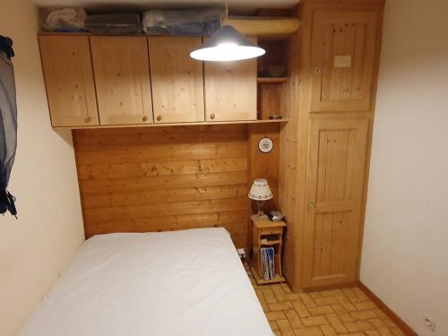 - une petite chambre avec un lit et une lampe dans l'établissement Appartement cosy à Châtel, 100m des pistes, 4 pers., terrasse sud, équipements cuisine complets - FR-1-676-185, à Châtel