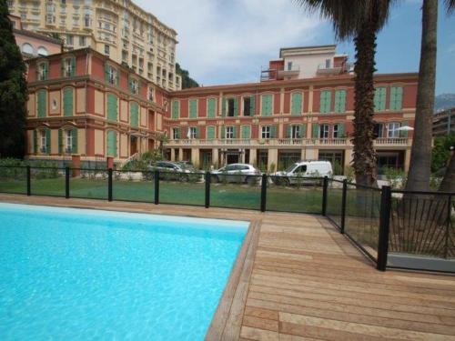 une piscine en face d'un grand bâtiment dans l'établissement Charmant 2P Central, Terrasse, Parking, Piscine - Menton - FR-1-196-363, à Menton