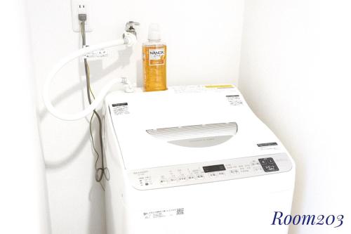 a washing machine with a bottle on top of it at SLEEPLAB THE STAY Casual 西新宿 in Tokyo