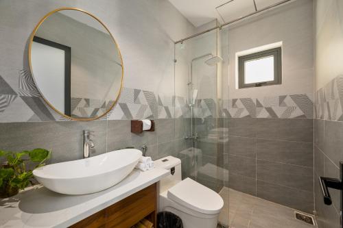 a bathroom with a sink and a mirror and a toilet at BS Jade Home Hội An in Hoi An