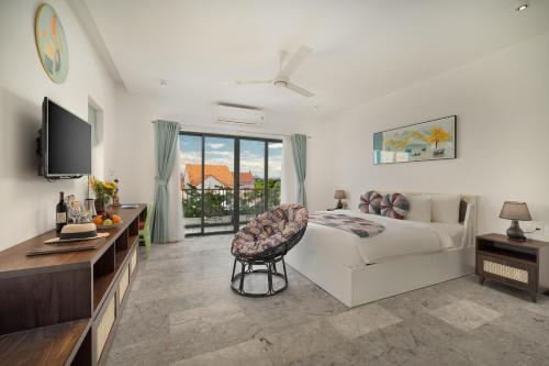 a bedroom with a bed and a tv and a couch at BS Jade Home Hội An in Hoi An