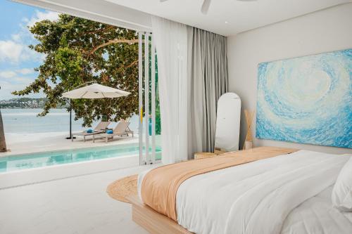 a bedroom with a bed and a view of the ocean at Bangrak Beachfront "Secret Tides" Villas in Bangrak Beach