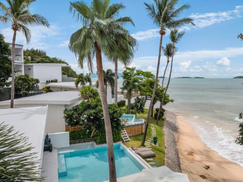 an aerial view of a resort with a swimming pool and the beach at Bangrak Beachfront "Secret Tides" Villas in Bangrak Beach