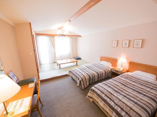a hotel room with two beds and a window at Hotel Harvest Skijam Katsuyama in Katsuyama