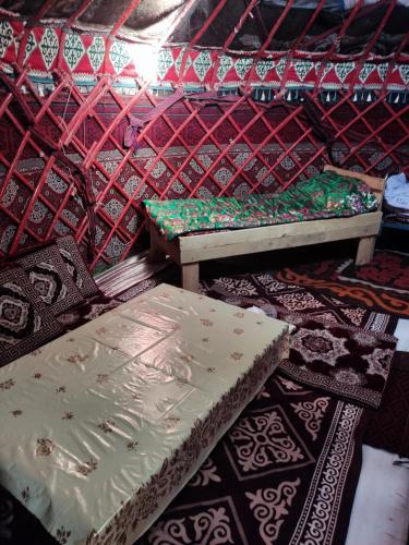 a room with two beds and a table on the floor at Nice Yurt Camp in Sary-Mogul