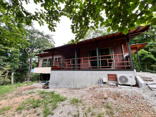 a small red house with a porch and a microwave at 流景邸 in Nasu-yumoto