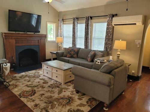 a living room with a couch and a tv at Luxury Historic North Hills Home in Knoxville