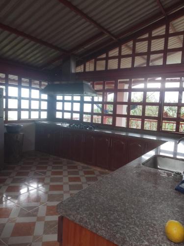 an empty kitchen with a counter top and windows at Finca La Vistosa in Sasaima