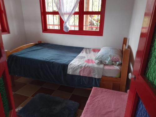 a small bedroom with a bed and a window at Finca La Vistosa in Sasaima