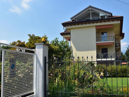a fence in front of a house with a building at Apartment in a prime location on Lake Maggiore in Verbania