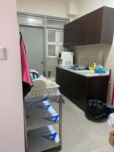a kitchen with a sink and a shelf with dishes at Suasana Damai Damansara Damai Petaling Jaya in Petaling Jaya