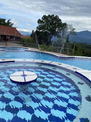 a large swimming pool with a water fountain at Finca La Vistosa in Sasaima