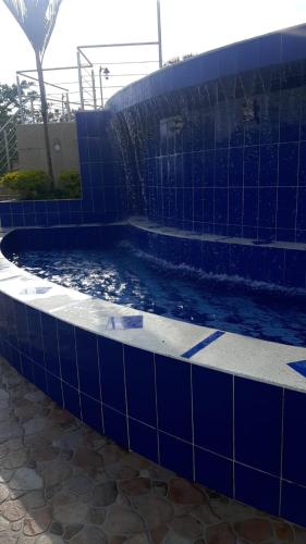 a blue tiled swimming pool in a building at Finca La Vistosa in Sasaima