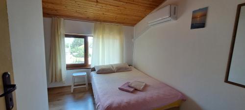 a small bedroom with a bed and a window at Holiday House Krapets in Krapets