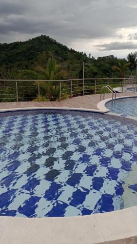 a large swimming pool with blue and white tiles at Finca La Vistosa in Sasaima