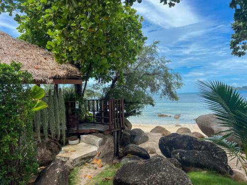 a hut on the beach with the ocean in the background at Siam Cookies Cottage in Haad Pleayleam