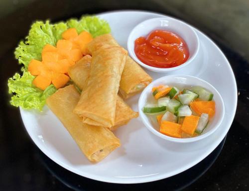 a white plate of food with carrots celery and vegetables at Camaradvipa Retreat Munduk in Munduk