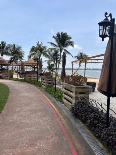 ジョホールバルにあるHomestay Ayuzizan CountryGarden Dangabay JBの椰子の木が生える浜辺の散歩道