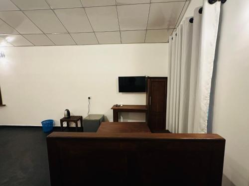 a room with a bed and a television and a desk at Walawe Palm Villa in Udawalawe