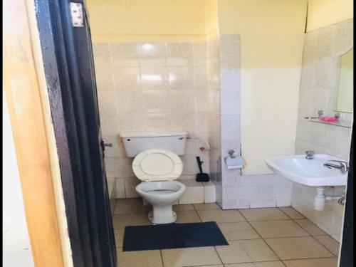 a bathroom with a toilet and a sink at Double Room With Balcony in the heart of city in Accra